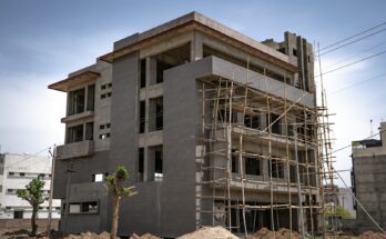 Gedung bertingkat dalam tahap pembangunan dengan perancah, ilustrasi cara mendirikan PT properti atau developer perumahan