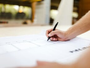 Tukang kayu merancang furnitur di bengkel kerja, ilustrasi KBLI furniture dan mebel