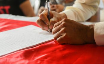 Seseorang menulis catatan di kertas, ilustrasi penyebab nama PT ditolak AHU dan cara mengatasinya