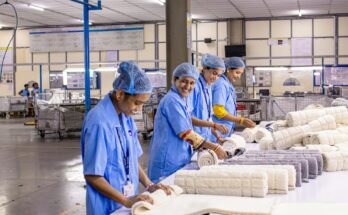 Pekerja pabrik tekstil menyortir dan menggulung kain, ilustrasi dampak usulan kenaikan UMP 2027 bagi industri padat karya